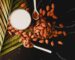 brown coffee beans on white ceramic mug beside stainless steel spoon