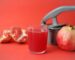 clear drinking glass with red liquid beside red apple fruit